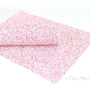 May include: Pink glitter fabric with a white background. The fabric is folded in half and the glitter is visible on both sides.
