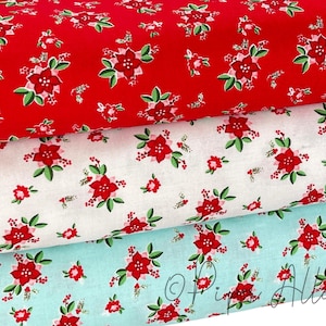 May include: Three fabric swatches with a red, white, and light blue background. Each swatch features a repeating pattern of red poinsettia flowers with green leaves.