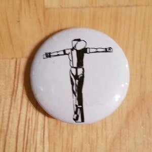 Op de afbeelding: Een witte knop met een zwart-witte illustratie van een persoon met uitgestrekte armen.