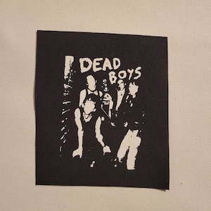 May include: Black and white patch with the text "DEAD BOYS" and a silhouette of a band with four members.