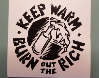 Op de afbeelding: Zwart-witte sticker met de tekst "Burn Out The Rich. Keep Warm." in een cirkel rond een tekening van een molotovcocktail.