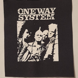 May include: Black and white patch with the text "ONEWAY SYSTEM" and an image of three people with mohawks.