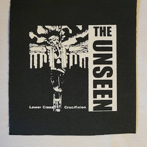 May include: Black and white patch with the text "THE UNSEEN" and the words "Lower Class Crucifixion" at the bottom.
