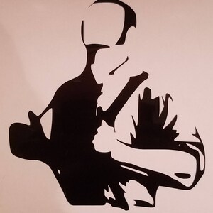 May include: Black silhouette of a person with a shaved head, wearing a shirt, holding a large object in their right hand.