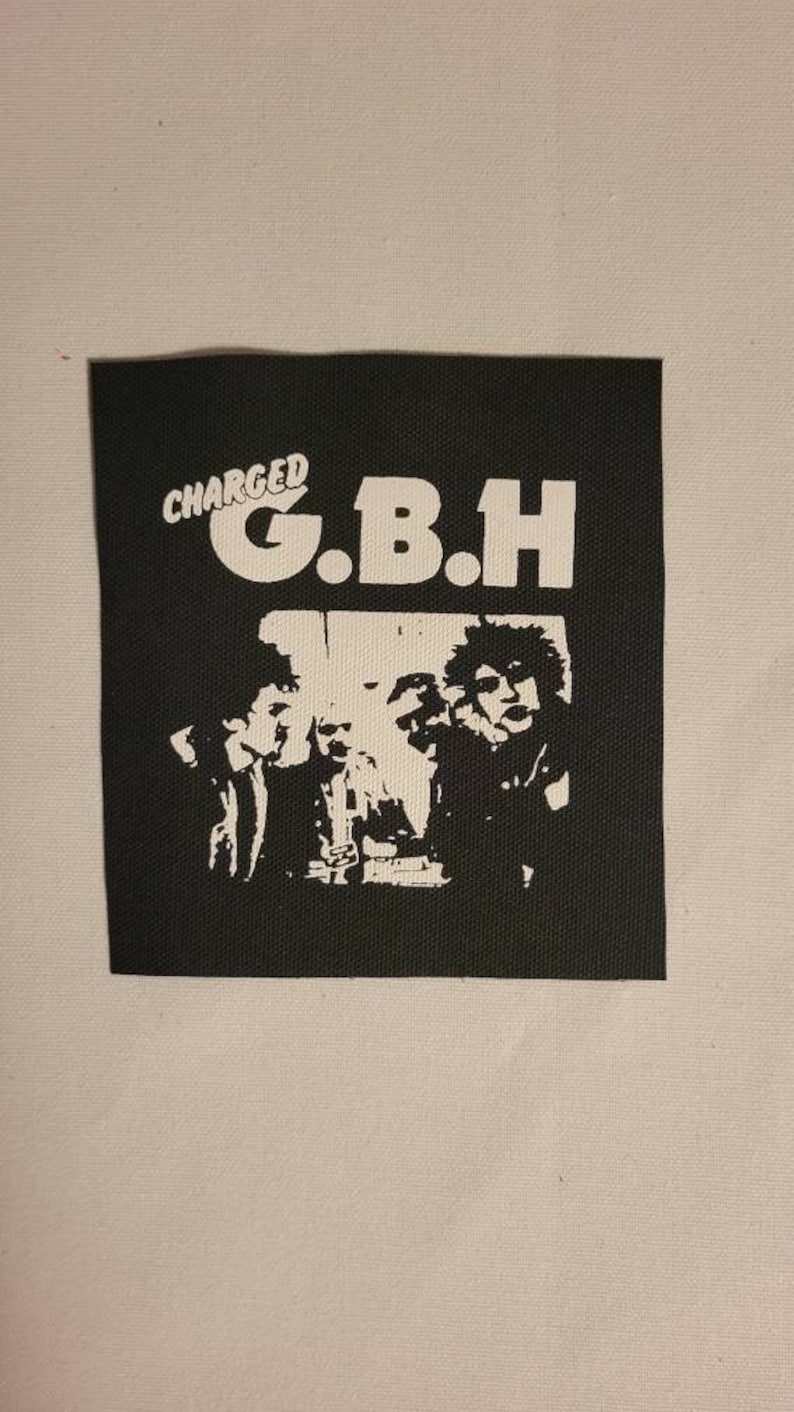 K&ouml;nnte beinhalten: Schwarz-wei&szlig;-Patch mit dem Text "CHARGED G.B.H." und einem Bandfoto.