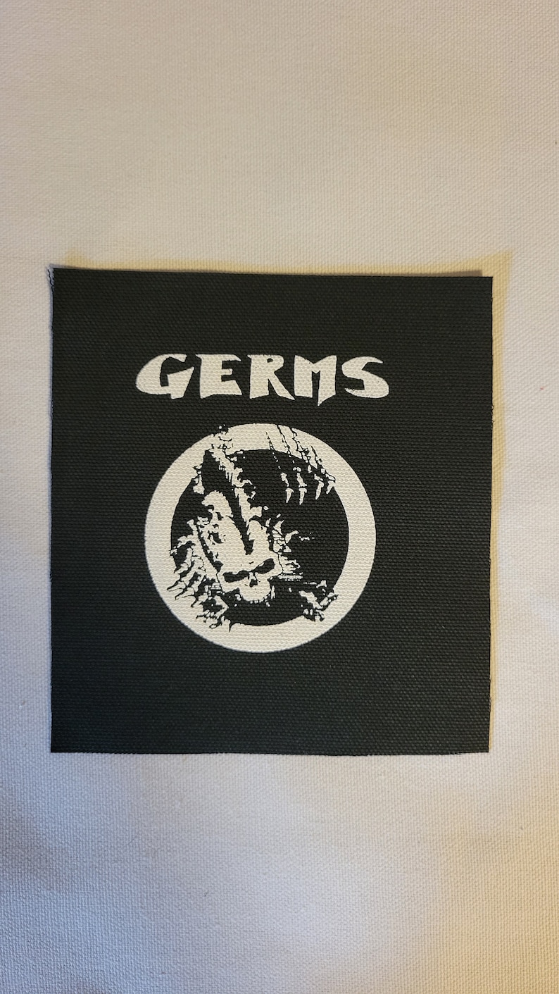 May include: Black and white embroidered patch with the word "GERMS" and a skull inside a circle.