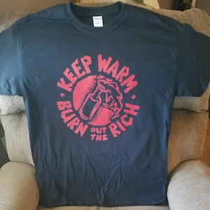 May include: A black t-shirt with a red circle graphic that says "Keep Warm - Burn Out The Rich" with a stylized image of a Molotov cocktail inside the circle.