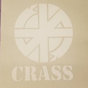 Può includere: Un adesivo bianco con un design circolare e la parola "CRASS" stampata sotto.