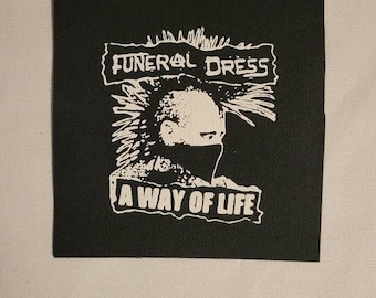 May include: Black and white patch with the text "FUNERAL DRESS" and "A WAY OF LIFE" with a punk rock style illustration of a person with a mohawk and a mask.