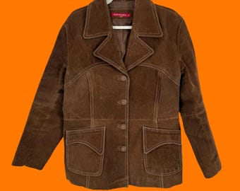 May include: A brown suede jacket with a notched collar, button closure, and two front pockets. The jacket has white stitching details and is hanging on a white hanger. The label reads "Sonny's".
