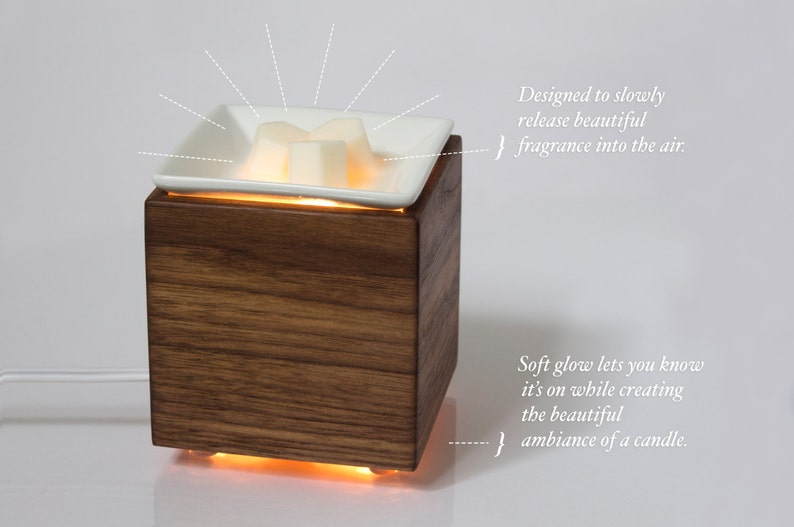 May include: A wooden diffuser with a white ceramic dish on top. The dish contains wax melts that are melting and releasing a fragrance into the air. The diffuser has a soft glow that lets you know it's on.