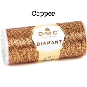 May include: A spool of copper-colored metallic thread labeled "DMC Diamant" with a horse logo.