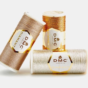 Puede incluir: Tres carretes de hilo de bordar metálico DMC Diamant. Los carretes son dorados, plateados y oro rosa.