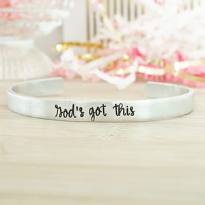 Könnte beinhalten: Ein silbernes Armband mit der Gravur "God's got this".