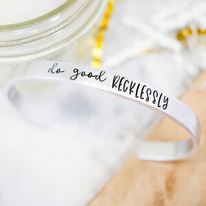May include: Silver bracelet with the inscription "do good recklessly".