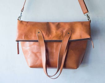 Messenger, cross body and fold over bag in leather. Use as tote or shopping bag. For men and women as laptop, grocery and school bag