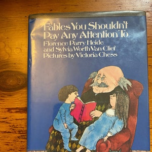 May include: A book cover with a blue background and the title "Fables You Shouldn't Pay Any Attention To" by Florence Parry Heide and Sylvia Worth Van Clief. The cover features an illustration of a man reading a book to two children.
