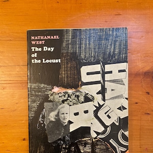 Può includere: Una copertina di libro in bianco e nero con il titolo "The Day of the Locust" di Nathanael West. La copertina presenta un collage di immagini, tra cui il viso di una donna e la parola "HAWAII" in grandi caratteri grassetto.