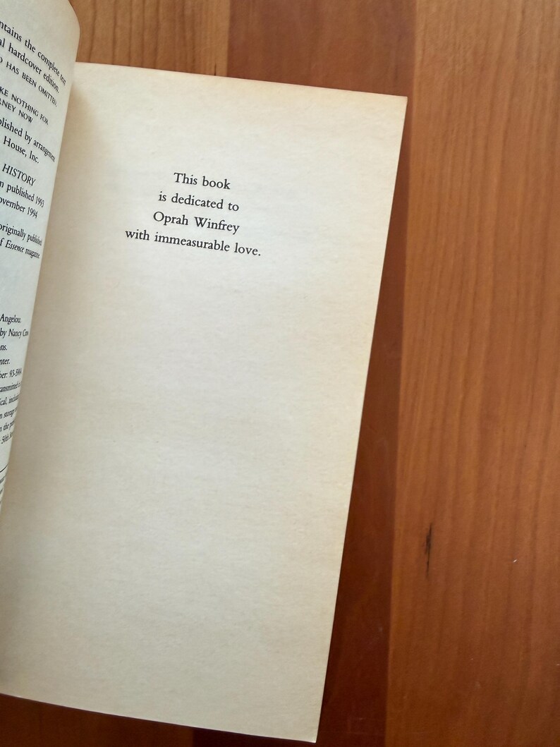 K&ouml;nnte beinhalten: Offene Buchseite mit dem Text: &bdquo;Dieses Buch ist Oprah Winfrey mit unermesslicher Liebe gewidmet.&ldquo; Die Seite ist cremefarben, der Text ist schwarz. Das Buch liegt auf einer Holzoberfl&auml;che.