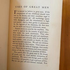 Pu&ograve; includere: Una pagina di un libro vintage intitolato "Uses of Great Men". Il testo discute l'importanza degli uomini grandi nella societ&agrave; e come le loro vite e le loro opere ci ispirano.