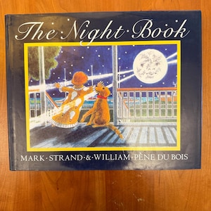 May include: A hardcover children's book titled "The Night Book" with a colorful illustration. The cover art depicts a child and a dog on a deck under a starry night sky with a full moon. The author's names are also visible.