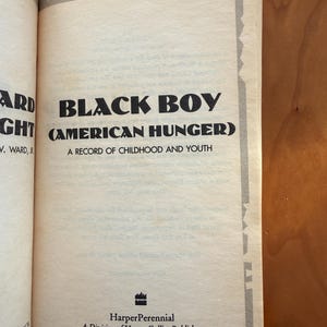Op de afbeelding: Een open boekpagina met de titel "BLACK BOY (AMERICAN HUNGER)" in vette zwarte letters. De ondertitel luidt "A RECORD OF CHILDHOOD AND YOUTH". Het HarperPerennial-logo en de uitgeversinformatie staan onderaan.