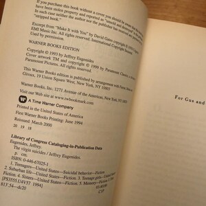 Op de afbeelding: Open boekpagina's met tekst uit "The Virgin Suicides" van Jeffrey Eugenides. De tekst bevat copyrightinformatie, uitgeversgegevens en Library of Congress Cataloging-in-Publication Data. Het boek is een Warner Books Edition.