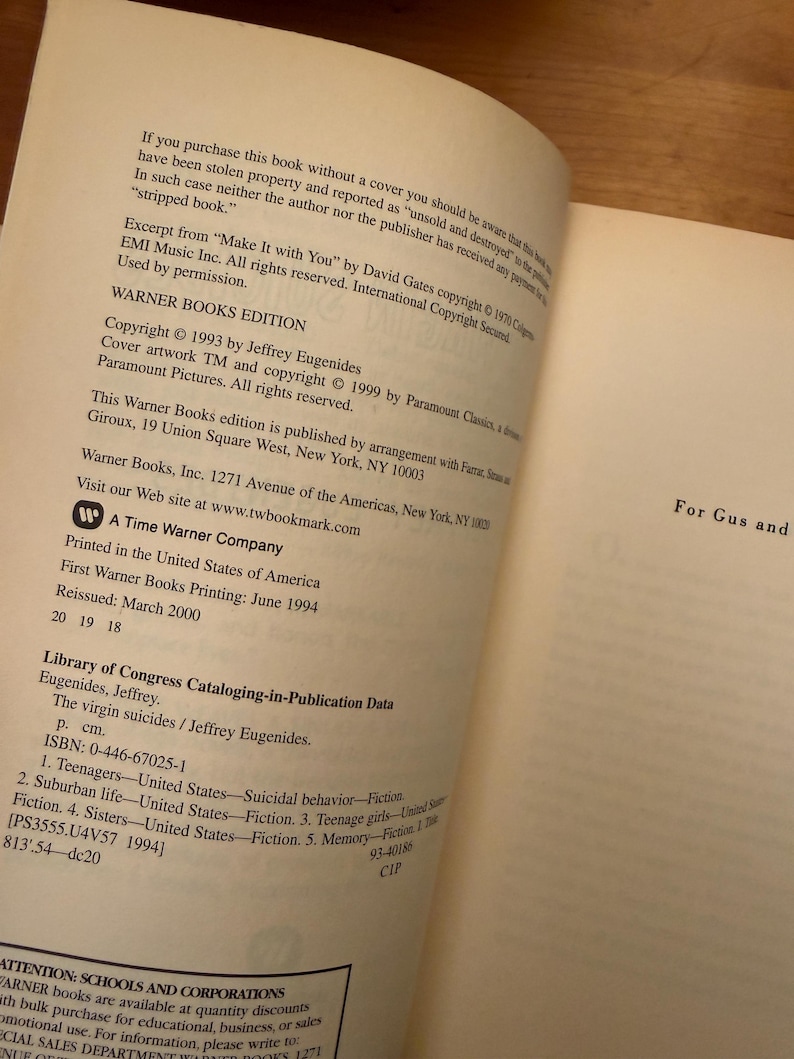 Op de afbeelding: Open boekpagina's met tekst uit "The Virgin Suicides" van Jeffrey Eugenides. De tekst bevat copyrightinformatie, uitgeversgegevens en Library of Congress Cataloging-in-Publication Data. Het boek is een Warner Books Edition.