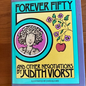 May include: A book cover with a turquoise, yellow, and pink design. The title is "FOREVER FIFTY AND OTHER NEGOTIATIONS BY JUDITH VIORST". The cover features a cartoon illustration of a woman with curly hair and a red apple.