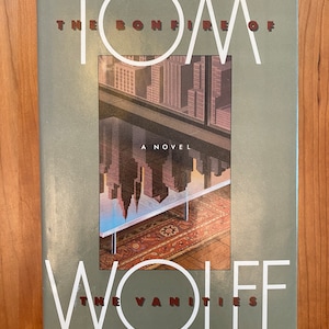 May include: A book cover with a green background and the title "The Bonfire of the Vanities" by Tom Wolfe. The cover features a cityscape reflected in a glass table.