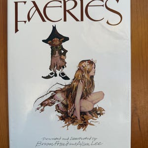 May include: A book cover titled "FAERIES" with illustrations of a fairy and a goblin. The cover features the text "Described and Illustrated by Brian Froud and Alan Lee" and "Edited and Designed by David Larkin."