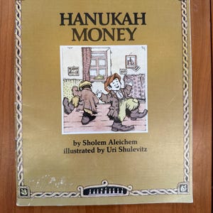 May include: A set of three ceramic mugs with a speckled, matte finish. The mugs are in shades of cream, light gray, and dark gray. Each mug has a simple, minimalist design and a rounded handle.