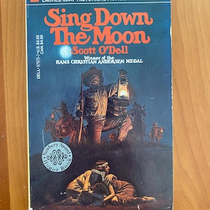 Puede incluir: Libro de bolsillo vintage titulado "Sing Down The Moon" de Scott O'Dell. La portada presenta una escena nocturna con figuras a caballo y un hombre con una linterna. El libro es un Newbery Honor Book y forma parte de la serie Laurel-Leaf Historical Fiction.