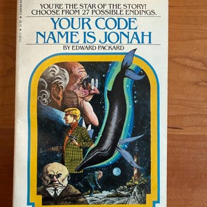 May include: A vintage paperback book titled "Your Code Name Is Jonah" from the "Choose Your Own Adventure" series. The cover features illustrations of a whale, a man with a gun, and other characters. The book is illustrated by Paul Granger.