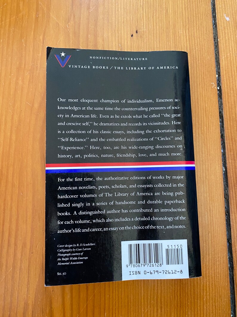 K&ouml;nnte beinhalten: Ein Vintage-Paperback-Buchcover mit schwarzem Hintergrund und wei&szlig;em Text. Das Buch tr&auml;gt den Titel "The Library of America" und enth&auml;lt ein Zitat von Ralph Waldo Emerson. Das Buchcover enth&auml;lt au&szlig;erdem einen Barcode und eine ISBN-Nummer.