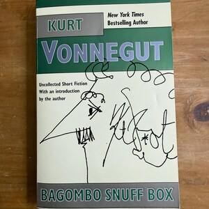 May include: A book cover for "Bagombo Snuff Box" by Kurt Vonnegut. The cover features the author's name in large, green letters, with the title at the bottom. The cover also includes a drawing and signature by the author.