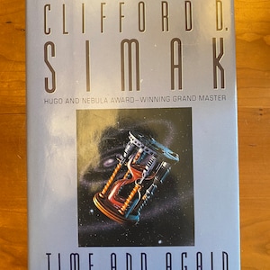 May include: A blue book cover with the title "Time and Again" by Clifford D. Simak. The book is a Collier Nucleus Science Fiction Classic and a Hugo and Nebula Award-winning Grand Master.