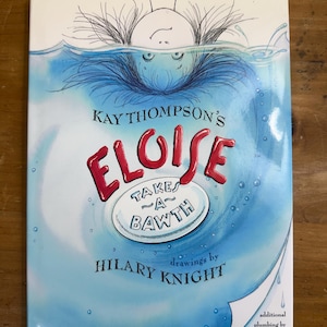 May include: A hardcover book titled "Eloise Takes a Bawth" by Kay Thompson, with illustrations by Hilary Knight. The cover features a whimsical illustration of a person submerged in water, with the title in red and a white oval with text.