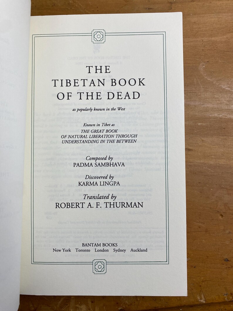Puede incluir: El Libro Tibetano de los Muertos, una portada de libro con el t&iacute;tulo en texto negro sobre fondo blanco. El libro es conocido en el T&iacute;bet como "El Gran Libro de la Liberaci&oacute;n Natural a trav&eacute;s de la Comprensi&oacute;n en el Intermedio". Fue compuesto por Padma Sambhava y descubierto por Karma Lingpa. El libro fue traducido por Robert A.F. Thurman.