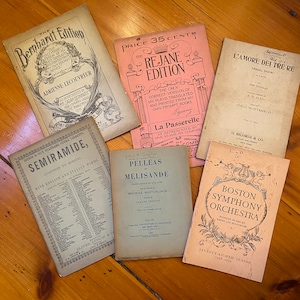 May include: A collection of vintage playbills for theatrical productions. The playbills are printed on paper with black ink and feature titles such as "Semiramede", "Pelleas et Melisande", "L'Amore dei Tre Re", "The Rejane Edition", and "Boston Symphony Orchestra".