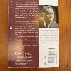 May include: The back cover of the book Black Boy by Richard Wright, featuring a black and white portrait of the author, a maroon background with white text, a summary of the autobiography, and a barcode with ISBN 0-06-092978-2 printed on it.