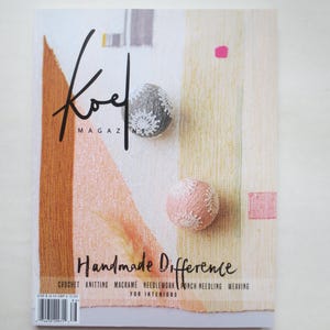 Op de afbeelding: Koel Magazine cover met de tekst "Handmade Difference" en een kleurrijke geweven stoffen achtergrond met twee kleine, witte, gehaakte ballen.