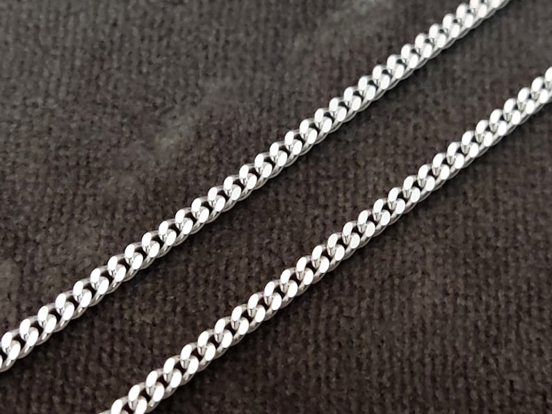 K&ouml;nnte beinhalten: Eine silberne Curb-Kette mit klassischem Design. Die Kette besteht aus miteinander verbundenen Metallgliedern, die ein robustes und stilvolles Schmuckst&uuml;ck bilden.