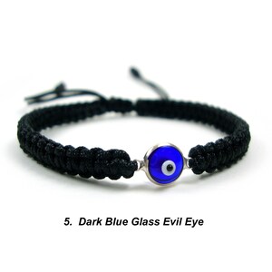 May include: Black braided bracelet with a dark blue glass evil eye charm.
