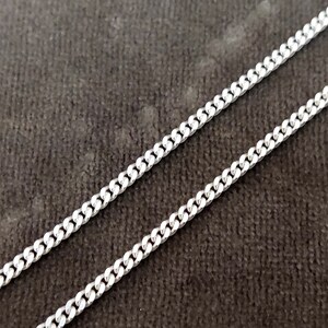 K&ouml;nnte beinhalten: Eine silberne Curb-Kette. Die Kette besteht aus kleinen, ineinandergreifenden Gliedern.