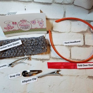 May include: A set of hair accessories for girls, including a gray crochet knit elastic headband, a red fold-over elastic headband, an orange hard headband, a spring barrette, a snap clip, and an alligator clip. The text "Baopies CLOSET" is visible on a card in the background.