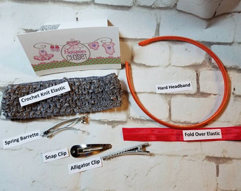 May include: A set of hair accessories for girls, including a gray crochet knit elastic headband, a red fold-over elastic headband, an orange hard headband, a spring barrette, a snap clip, and an alligator clip. The text "Baopies CLOSET" is visible on a card in the background.
