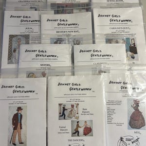 May include: A collection of applique quilt pattern series titled "Bonnet Girls: Gentlewomen." The patterns feature various designs, including "Grandma's Kitchen," "School Days," and "Adam." Each pattern is packaged in a clear plastic sleeve.