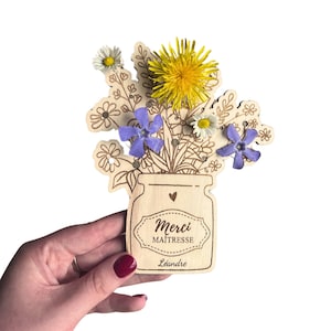 Personnalisez ce vase en bois avec le message Merci Maîtresse pour un cadeau original et mémorable. Les petits trous invitent à ajouter des fleurs, offrant ainsi une décoration à la fois esthétique et pratique.