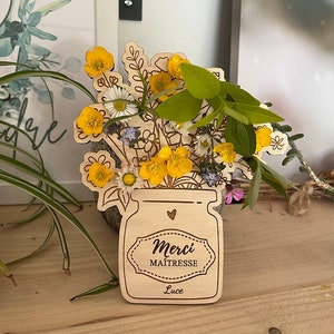 Personnalisez ce vase en bois avec le message de remerciement Merci Maîtresse pour créer un cadeau unique et raffiné. Les petits trous permettent d'ajouter des fleurs